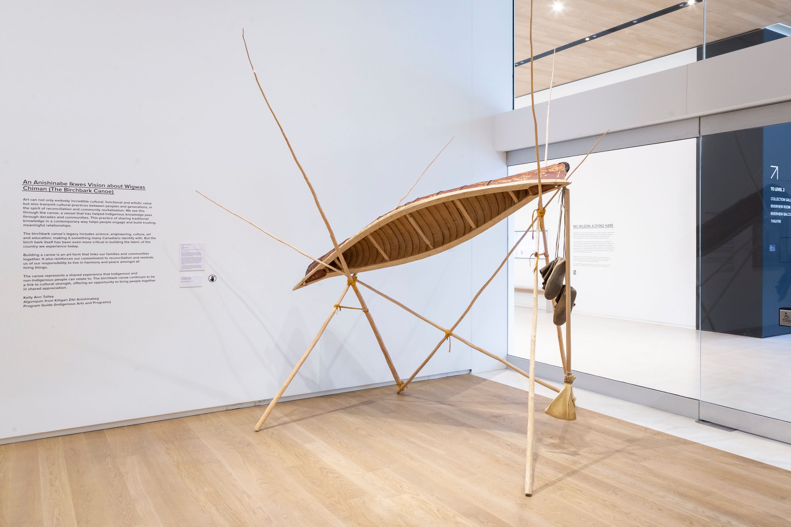 A birchbark canoe sits on wooden supports in Remai Modern's Connect Gallery.