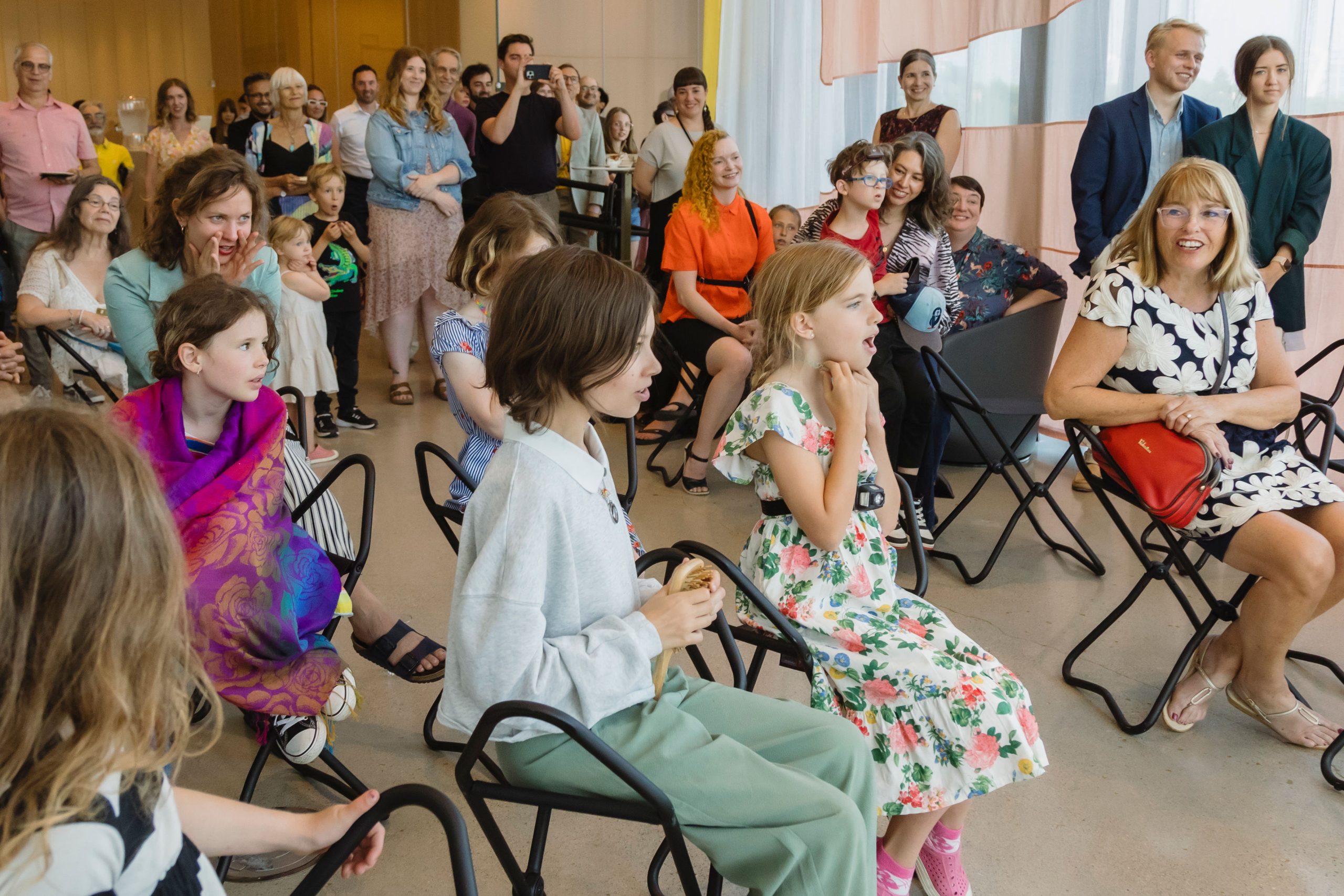 A crowd of people, including numerous children, gathers for an exhibition opening at Remai Modern.