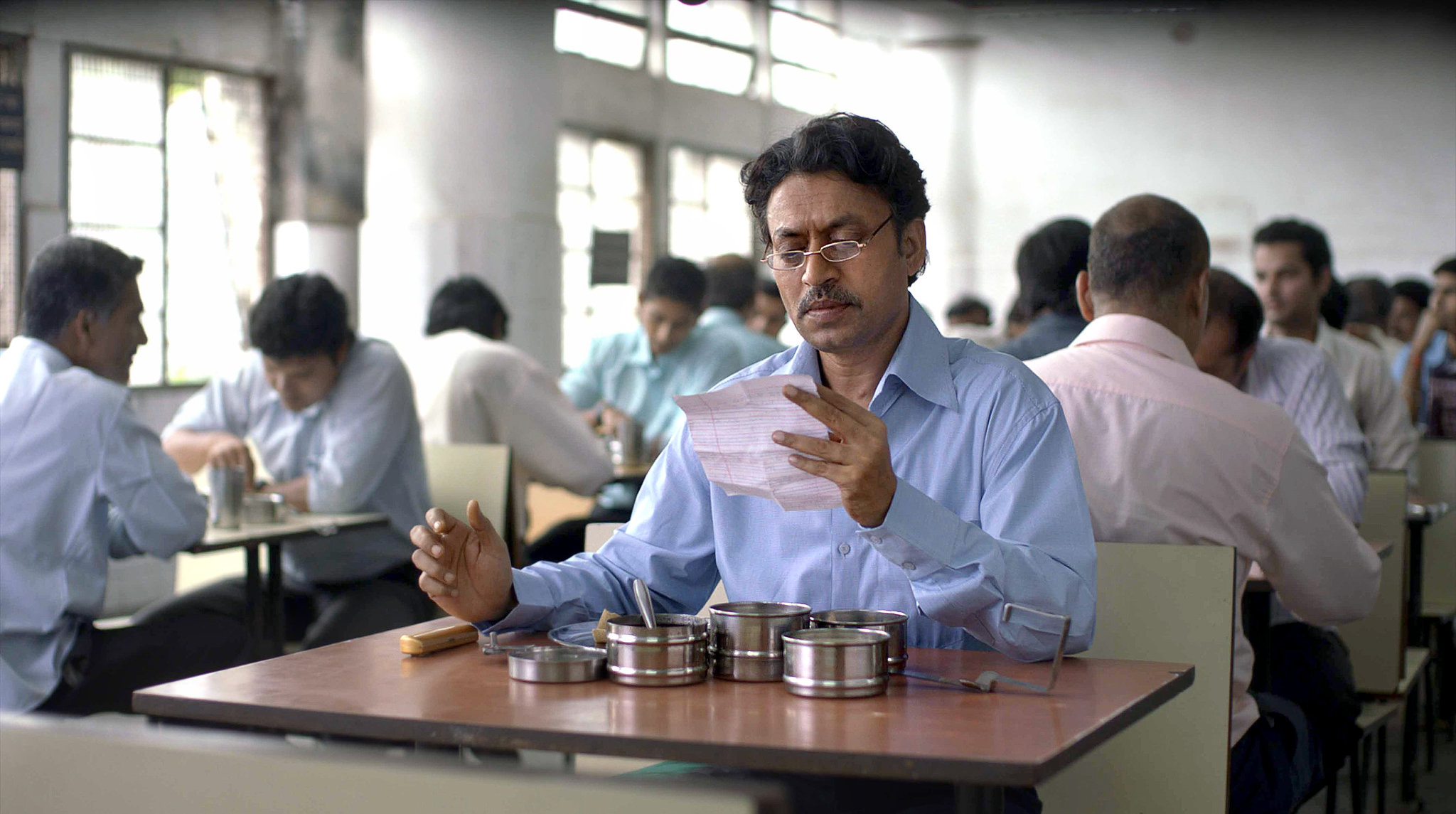 A man sitting at a table in a cafeteria